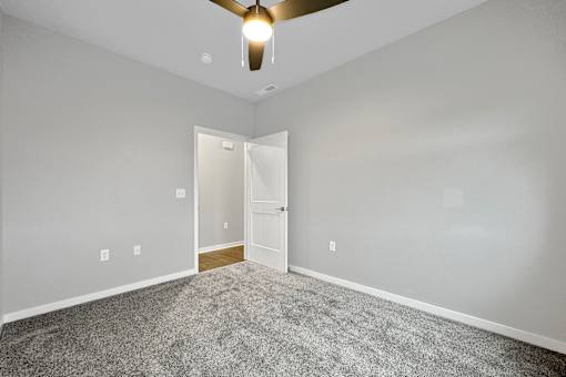 an empty room with carpet and a ceiling fan at Converge NW, Waukee Iowa  