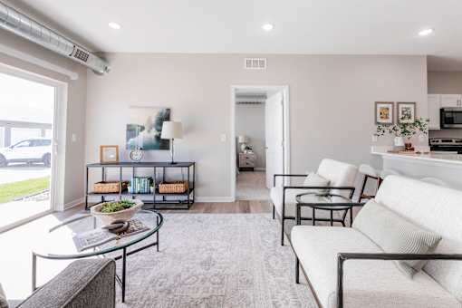 A living room with a glass coffee table and a white sofa.at Converge NW, Waukee  