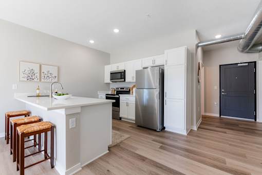 A kitchen with a white counter top and a refrigerator.at Converge NW, Iowa, 50263