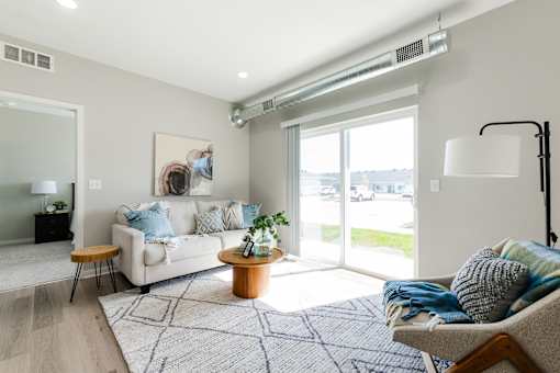 A living room with a white couch, a wooden coffee table, and a large window.at Converge NW, Iowa  