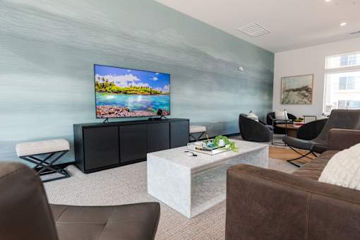 a living room with couches and chairs and a tv on the wall at Converge NW, Iowa, 50263