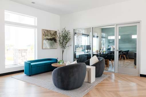 a living room with blue and black furniture and glass doors at Converge NW, Iowa, 50263