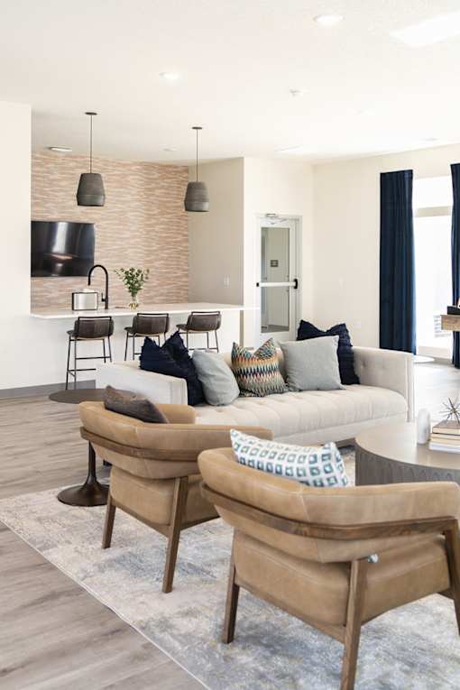 a living room with a couch and chairs and a kitchen at Forge65, Pleasant Hill, IA, 50327