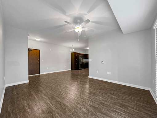 A spacious room with wood flooring and a ceiling fan. at Stonegate Crossing Apartments, Clive, 50325
