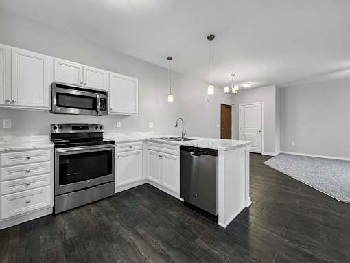 an empty kitchen with white cabinets and stainless steel appliances at Stonegate Crossing Apartments, IOWA, 50325