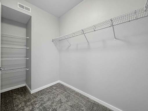 a closet in a white room with a mirrored closet door at Stonegate Crossing Apartments, IOWA