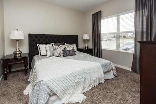 a bedroom with a bed and a window at Stonegate Crossing Apartments, IOWA, 50325