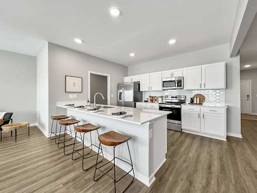 a large typographic wall in a room with bar stools at Rialto Townhomes Apartments, Iowa, 50263