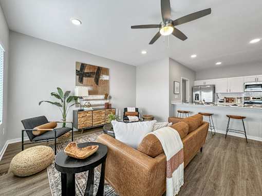 a living room with a couch and a ceiling fan at Rialto Townhomes Apartments, Waukee, 50263