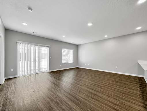 an empty living room with wood flooring and a window at Rialto Townhomes Apartments, Waukee