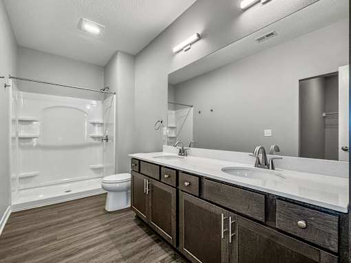 a bathroom with a sink and a toilet and a shower at Rialto Townhomes Apartments, Iowa