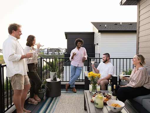a group of people standing on a balcony with drinks at Rialto Townhomes Apartments, Iowa, 50263