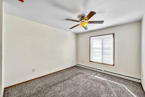 an empty room with a ceiling fan and a window at Penbrooke Place Apartments, Sioux Falls, SD