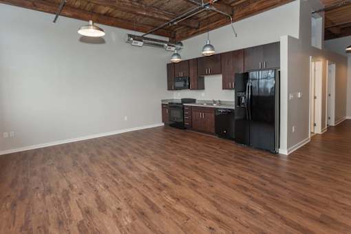 A kitchen with black appliances and wooden floors at Spaulding Lofts Apartments, Grinnell, Iowa