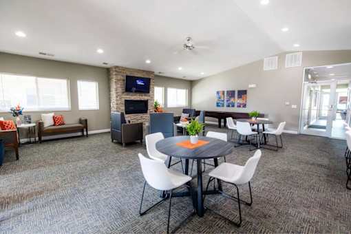 A conference room with a table, chairs, and a television on the wall.