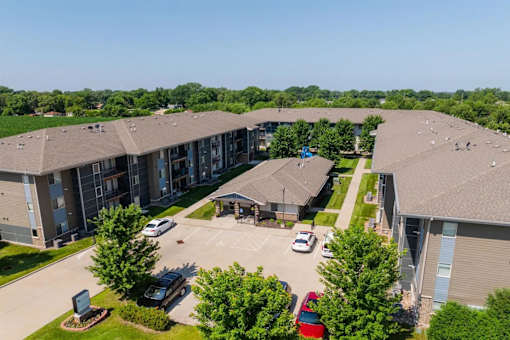 A large apartment complex with a parking lot in front.