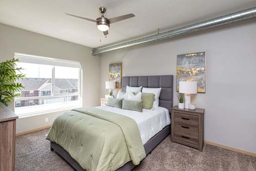 a bedroom with a large bed and a ceiling fan at Lake Shore Apartments, Iowa, 50021
