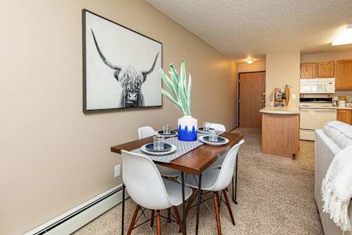 our apartments offer a dining room table with chairs and a view of the kitchen at Lake Shore Park, Iowa