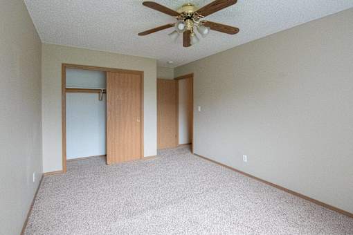 A room with a ceiling fan and carpeted floor at Peach Tree Apartments, Ankeny, IA,  50021