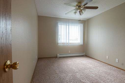 A room with a ceiling fan and a window with blinds at Peach Tree Apartments, Iowa, 50021