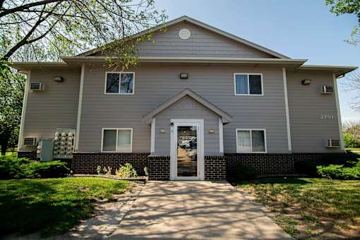 a white house with a sidewalk in front of it at Peach Tree Apartments, Ankeny