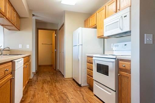 a kitchen with wood flooring and white appliances at Sunrise Meadows, Waukee