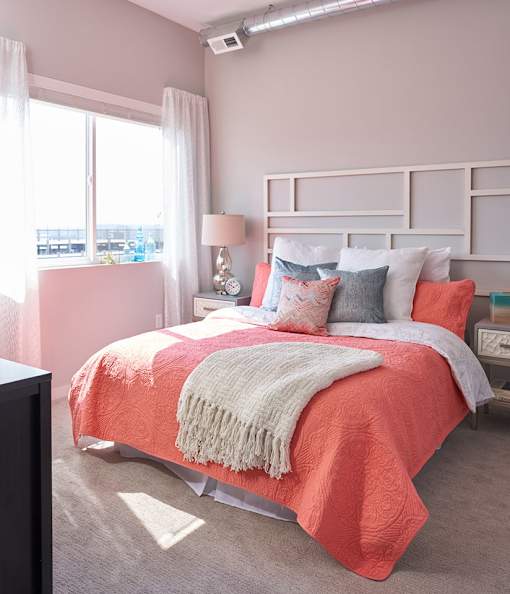 a bedroom with a bed and pillows and a window at Vue Apartments, IA, 50309