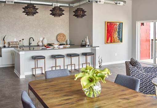 a dining room with tables and chairs and potted plants at Vue Apartments, Iowa, 50309