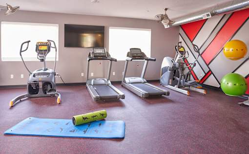 a gym with exercise equipment and weights on the floor at Vue Apartments, Des Moines, Iowa