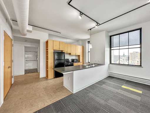 A spacious office with a kitchenette and a view of the city at The Des Moines Building Apartments, Des Moines, IA, 50309