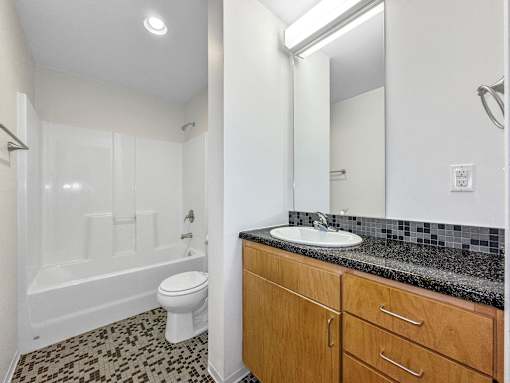 A bathroom with a toilet, sink, and shower at The Des Moines Building Apartments, IA, 50309