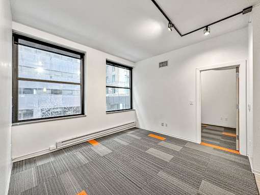 A room with grey carpet and windows overlooking a city at The Des Moines Building Apartments, Des Moines, IA, 50309