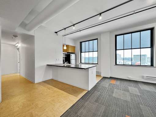 A room with a desk and a window overlooking a cityscape at The Des Moines Building Apartments, Iowa, 50309
