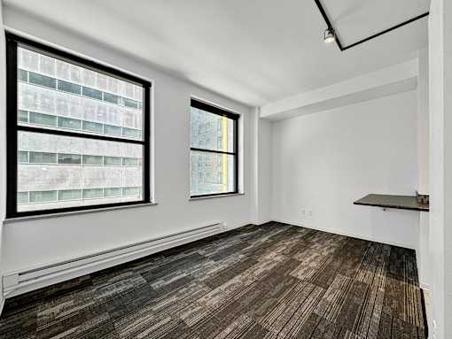 A room with a window and a wooden floor at The Des Moines Building Apartments, IA, 50309