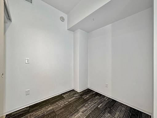A room with a white wall and a brown carpet at The Des Moines Building Apartments, Des Moines, IA