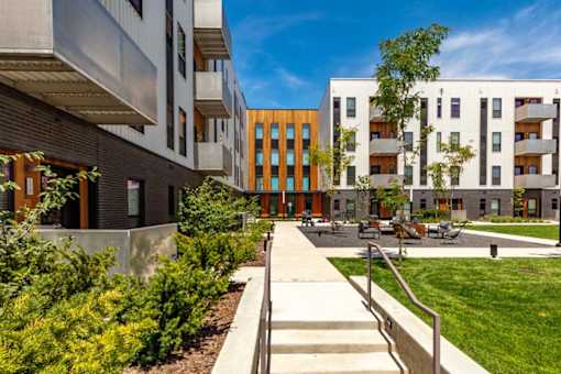 a group of modern buildings with a sidewalk and grass at Rowat Lofts, Des Moines  