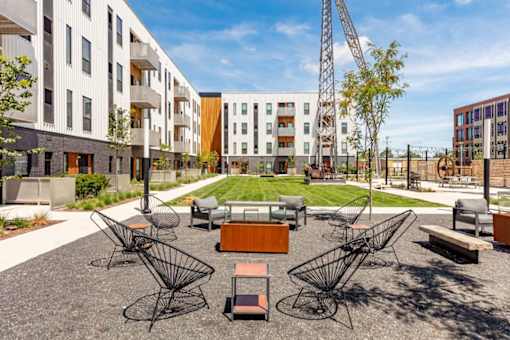 a courtyard with a table and chairs in front of an apartment building at Rowat Lofts, Iowa   