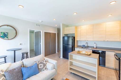 a living room with a couch and a kitchen at Rowat Lofts, Des Moines, 50309  