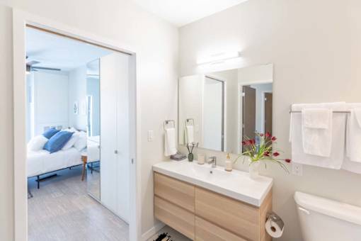 a bathroom with a large mirror and a sink at Rowat Lofts, Des Moines Iowa   
