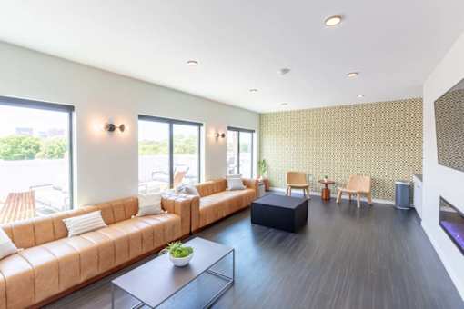 a living room with leather couches and a table at Rowat Lofts, Des Moines, 50309  