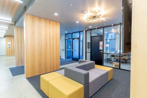 a room with couches and a wooden wall and a glass door at Rowat Lofts, Iowa   