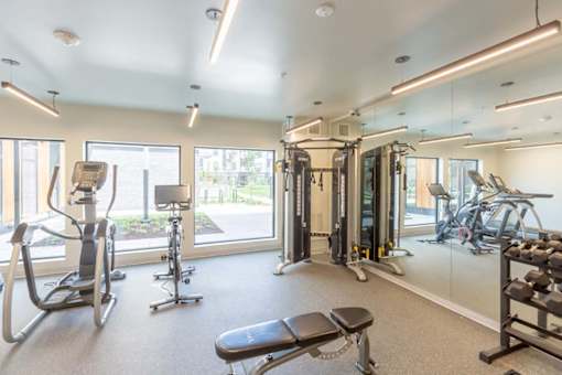 a gym with exercise equipment and a large window at Rowat Lofts, Des Moines, IA  