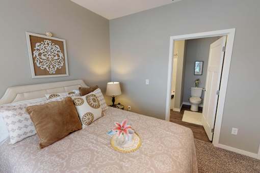 A bedroom with a large bed and a painting on the wall. at The Barclay Apartments, Altoona
