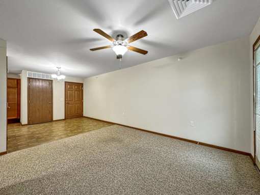A room with a ceiling fan and carpeted floor.at Cornerstone Commons, Iowa, 50131