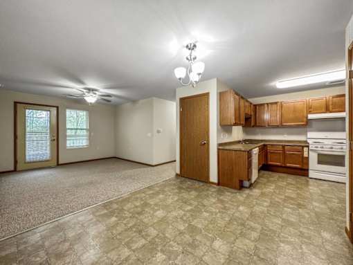 A kitchen with white appliances and wooden cabinets.at Cornerstone Commons, Iowa  