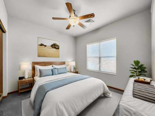 A bedroom with a large bed and a ceiling fan.at Cornerstone Commons, Johnston  