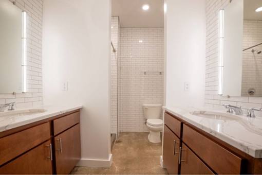 Bathroom with granite counter tops and a large mirror and storage at Clemens Building, Iowa , 50309