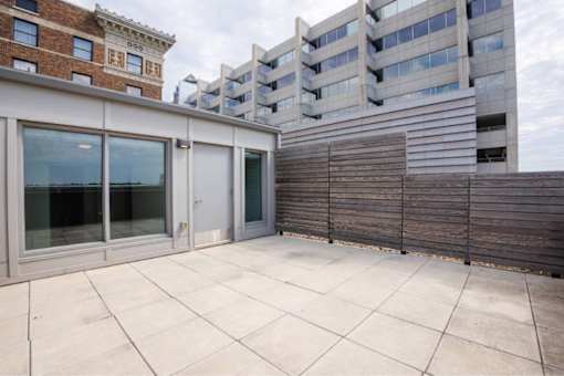 Patio with a sliding glass door and a wooden fence at Clemens Building, Des Moines