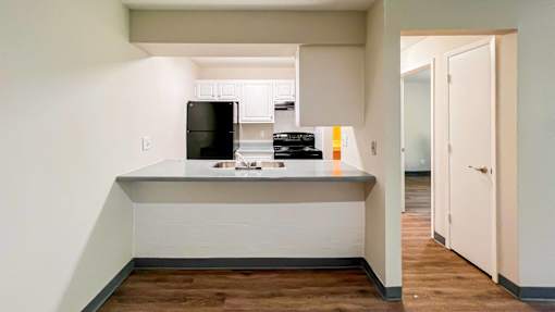 A kitchen with a black fridge and a black microwave at The Hampton Meadows Apartments, Des Moines, IA, 50315