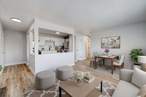 A modern living room with a kitchen in the background at The Hampton Meadows Apartments, IA,50315